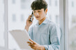 © Timeimage - Asian businessman is calling to discuss about the work by the window