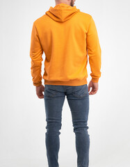 Poster - man standing in vibrant orange hoodie. isolated studio photo male wearing street clothing mock up. hoodie design template