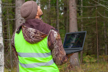 Wall Mural - Ecologist works in the forest with a computer.