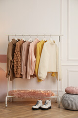Wall Mural - Rack with stylish warm clothes and shoes in modern dressing room