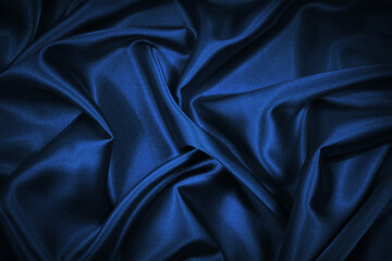 abstract blue black background. blue silk satin texture background. beautiful soft wavy folds on shi
