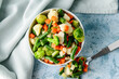 Frozen vegetables in bowl on light background
