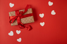 Gift Box With Red Ribbon And White Hearts On Red Background. A Gift For Valentine's Day. 
