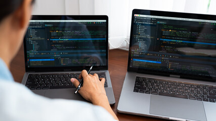 Wall Mural - Programmer or software developer Typing New Lines of Code, coding technologies working at wooden industrial interior work place station.