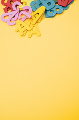 Poster - A top view closeup of the letters of the English alphabet isolated on a yellow background