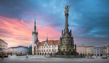Panorama Of Olomouc, Czech Republic At Sunset. The Square And The Holy Trinity Column Enlisted In The Unesco World Heritage List And Astronomical Clock In The Building Of The Town Hall 