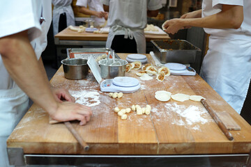 Taiwanese team of chefs cooking traditional food dumplings in the restaurant kitchen. Men hands cook and prepairing dough of dumpling.