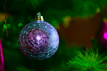 Beautiful multi-colored Christmas toys on the holiday tree with reflections of light