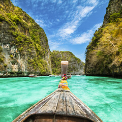 Wall Mural - Traditional wooden boat in a picture perfect tropical bay on Koh Phi Phi Island, Thailand, Asia.