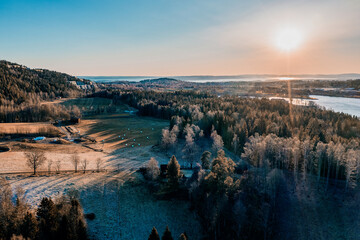 Drone photo shot from the sky. Countryside just outside of Oslo, Norway. Fields and wood mixed together. 