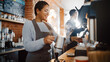 © Gorodenkoff - Beautiful Latin American Female Barista with Short Hair and Glasses is Making a Cup of Tasty Cappuccino in Coffee Shop Bar. Portrait of Happy Employee Behind Cozy Loft-Style Cafe Counter.