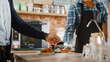 © Gorodenkoff - African American Customer Pays for Coffee and Pastry with Contactless NFC Payment Technology on Smartphone to a Handsome Barista in Blue Checkered Shirt. Contactless Mobile Payment in Cafe Concept.