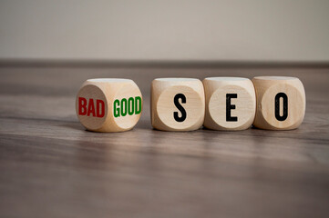 Cubes, dice or blocks with bad or good seo on wooden background