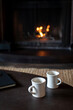 © Rachel Weill - Two mugs of coffee on a table in front of wood burning fireplace