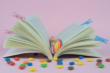 Wall Mural - A closeup shot of an open book with colorful candies and clothespins