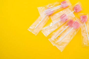 Sticker - A closeup shot of yummy candies in plastic bags isolated on a yellow background