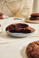 Poster - A vertical shot of delicious fudge chocolate cookie with ingredients on a white table