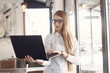 © prostooleh - Woman with a laptop. Busineswoman in a stylish clothes. Woman standing at the office.