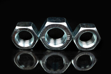 several large metal nuts on a black background