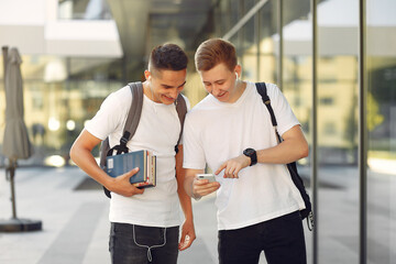 Students in a park. Boys in a university campus . Friends with a books.