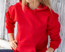 Unrecognizable Blon Woman Wears Red Hoodie. Casual Christmas Outfit. Clothing Design With Copy Space For Mockup.