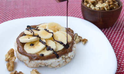 A closeup shot of dessert with bananas and chocolate cream on white plate