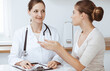 © rogerphoto - Doctor and patient are sitting and discussing health examination results in clinic office. Health care, medicine and good news concepts