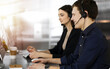 © rogerphoto - Call center operators at work. Two young people in headsets are talking to the clients, while sitting in sunny office