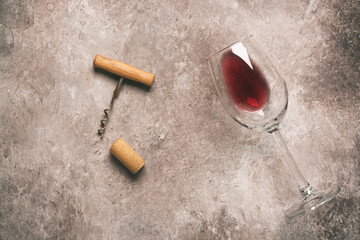 Wall Mural - Flat lay glass of red wine, corkscrew and cork. Beige grunge background. Wine tasting concept. Top view.