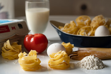 Homemade pasta with egg and tomatoes in white background