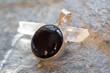 Sterling silver pendant with mineral onyx gemstone on rocky background