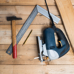 Poster - A top view of a setsquare, a hammer and  other repairing equipments on a wooden surface