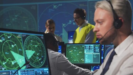 Wall Mural - Workplace of the air traffic controllers in the control tower. Diverse team of aircraft control officers works using radar, computer navigation and digital maps. Aviation concept.