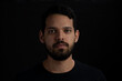 © Alejandro - Closeup frontal portrait of young men serious over black background.