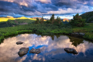 Poster - A mesmerizing shot of a lake and the amazing landscapes under the cloudy sky