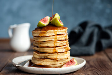 Wall Mural - Fluffy buttermilk pancakes with figs and syrup pouring over. Delicious appetizing stack of thick pancakes