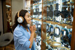 © Nomad_Soul - Woman trying on headphones in speaker system store