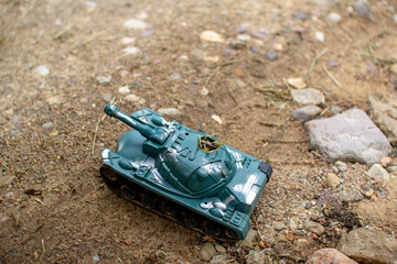 Toy plastic tank driving on the road and smoking