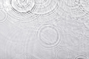 Wall Mural - A top view closeup of waterdrops falling on the surface and forming a circular shape