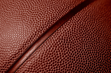 Closeup detail of basketball ball texture background. Red color filter. Banner art concept. Team sport