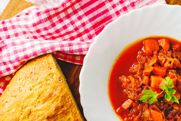 Top view on Borscht soup in plate - Fresh homemade Borsch traditional meal on table with copy space close up with slice of bread