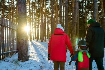 Canvas Print - parent and child walking in winter park