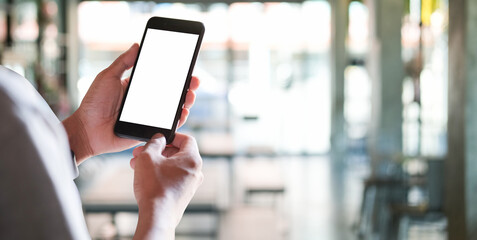 Wall Mural - close up view of male hands using smart phone with modern office blurred background.