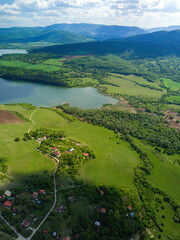 Poster - An vertical shot of the green landscapes, fields and a river under the cloudy sky on a sunny day