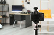 © Pixel-Shot - Professional camera on tripod in modern photo studio