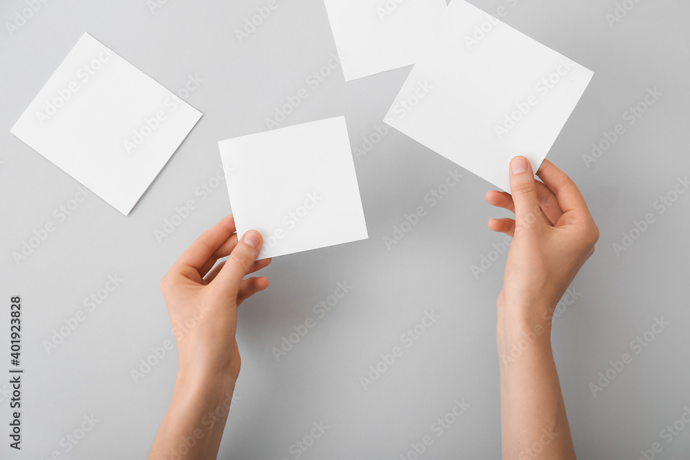 Female hands with blank paper on light background