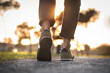 © Creative Cat Studio - Woman walking outdoors on sunset. Closeup on shoe with rolled up jeans. Taking a step. New life concept