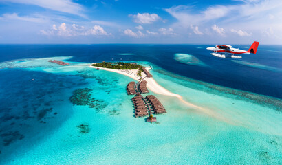 Wall Mural - a seaplane is approaching a tropical paradise island in the maldives with turquoise sea and sunshine