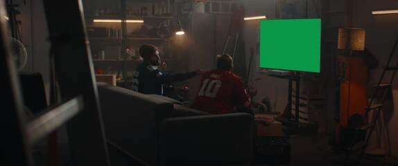 Wall Mural - GREEN SCREEN CHROMA KEY Friends playing console games inside their garage hideout, winning and celebrating. Shot with 2x anamorphic lens