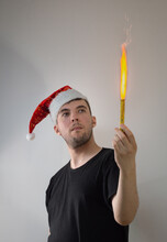 A Young Man In A Santa Hat With A Lit Torch In His Hands